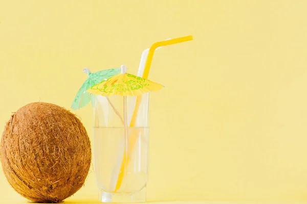 Friss kókuszdió koktéllal és sárga hátterű szalmával, másolási hellyel — Stock Fotó