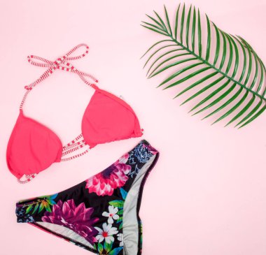 Şapka, pembe arka planda mayo ve güneş gözlüğü. Üst görünüm, düz yatıyordu, metin için alan