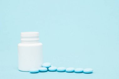 Mavi haplar ve pill şişe mavi zemin üzerine
