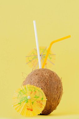 Sarı arka planda bir pipet ile taze Hindistan cevizi kokteyli, kopya alanı