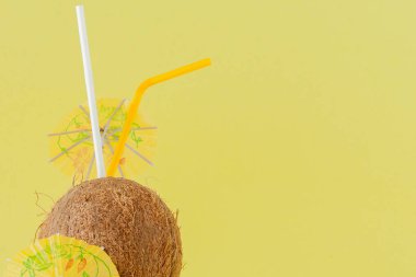 Sarı arka planda bir pipet ile taze Hindistan cevizi kokteyli, kopya alanı