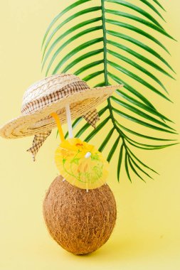 Sarı arka planda bir pipet ile taze Hindistan cevizi kokteyli