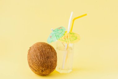 Sarı arka planda bir pipet ile taze Hindistan cevizi kokteyli, kopya alanı