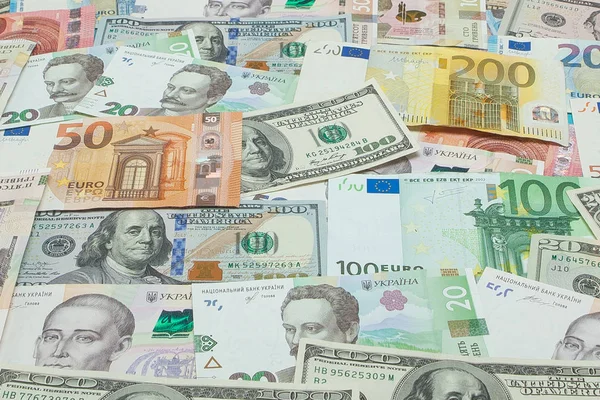 Concepto de dinero y finanzas. Billete nuevo de cien dólares sobre fondo abstracto colorido de billetes ucranianos, americanos y euro en moneda nacional — Foto de Stock