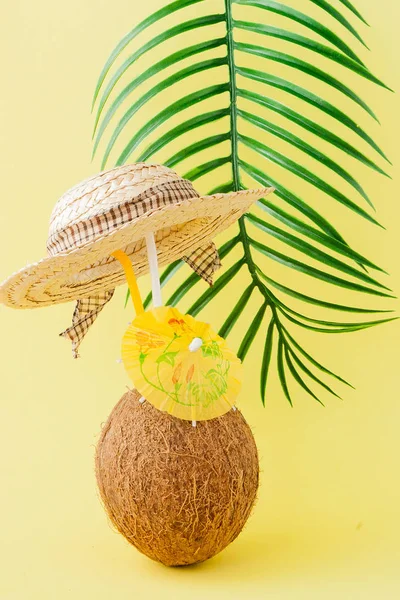 Sarı arka planda bir pipet ile taze Hindistan cevizi kokteyli