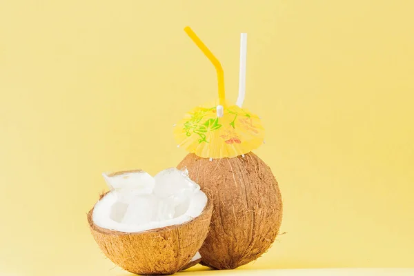 Cóctel de coco fresco con pajitas sobre fondo amarillo, espacio para copiar — Foto de Stock