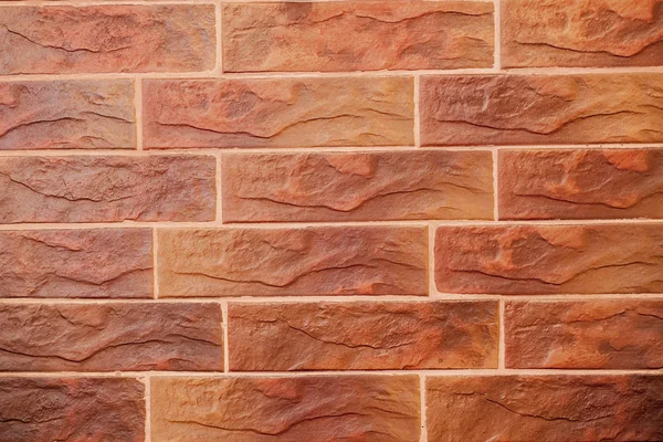 붉은 벽돌 벽입니다. 인공 결함과 균열이 있는 장식적인 벽돌. 벽돌의 형태로 장식 타일의 질감 — 스톡 사진