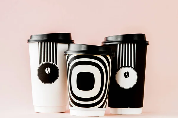 Café para llevar en una taza termo sobre un fondo rosa — Foto de Stock