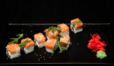 Suşi rulo somon ve avokado ile plaka üzerinde siyah arka plan Üstten Görünüm