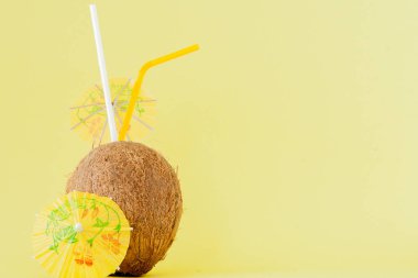 Sarı arka planda bir pipet ile taze Hindistan cevizi kokteyli, kopya alanı