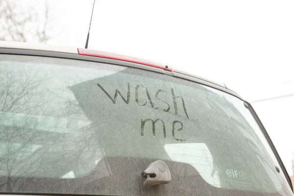 Write the words wash me on the very dirty surface of the car. Concept car wash
