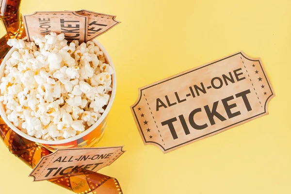Movie tickets, film strips and popcorn on blue background. Copy