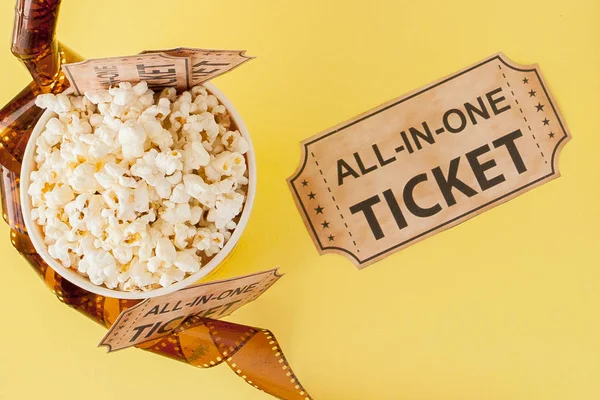 Filmbiljetter, filmremsor och popcorn på blå bakgrund. Uppfattat. — Stockfoto