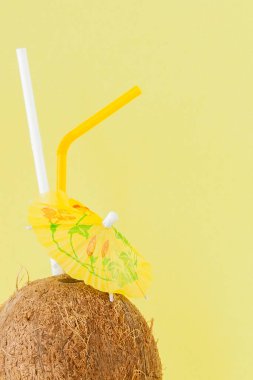 Sarı arka planda bir pipet ile taze Hindistan cevizi kokteyli, kopya alanı