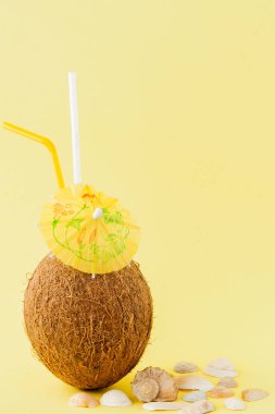 Sarı arka planda bir pipet ile taze Hindistan cevizi kokteyli, kopya alanı