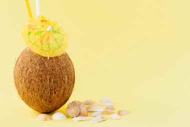 Sarı arka planda bir pipet ile taze Hindistan cevizi kokteyli, kopya alanı