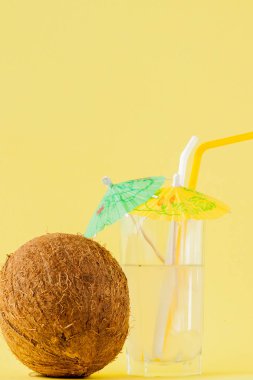 Sarı arka planda bir pipet ile taze Hindistan cevizi kokteyli, kopya alanı