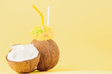 Sarı arka planda bir pipet ile taze Hindistan cevizi kokteyli, kopya alanı