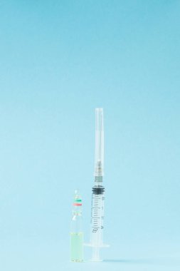 Ampul ve şırınga mavi zemin üzerine kapatalım. kopya alanı