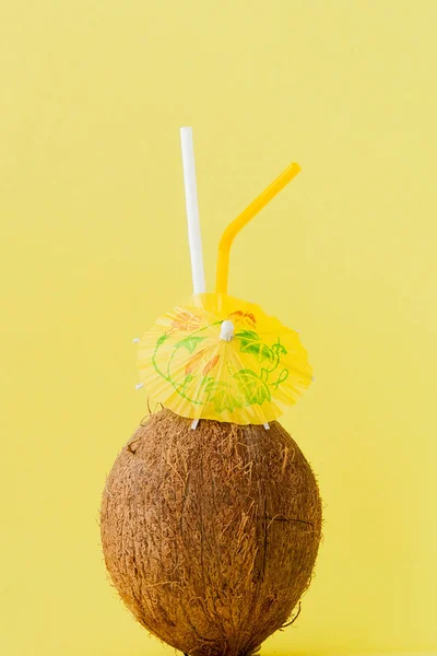 Cocktail de noix de coco fraîche avec une paille sur fond jaune, espace de copie — Photo