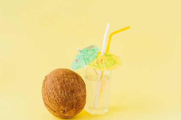 Cóctel de coco fresco con pajitas sobre fondo amarillo, espacio para copiar — Foto de Stock