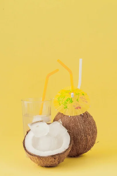 Cocktail de noix de coco fraîche avec une paille sur fond jaune — Photo