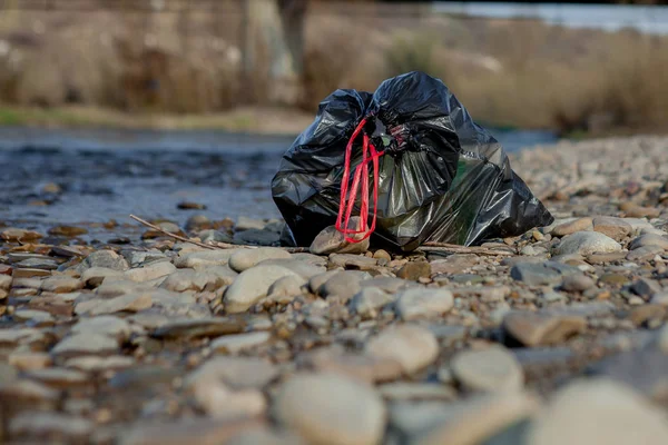 River pollution near the shore, garbage pack near the river, plastic food waste, contributing to pollution