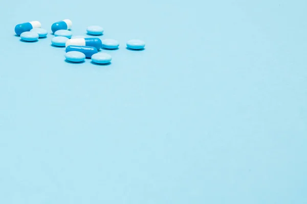 Scattered blue pills on blue table. Mock up for special offers a