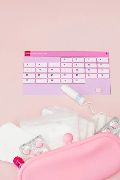 Tampon, feminine Damenbinden für kritische Tage, femininer Kalender, Schmerztabletten während der Menstruation auf rosa Hintergrund. Den Menstruationszyklus und den Eisprung verfolgen — Stockfoto