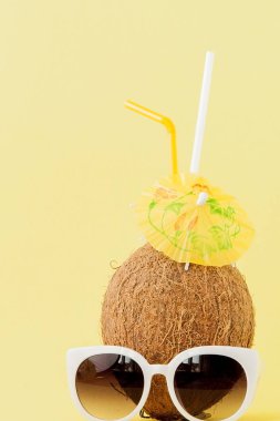 Sarı arka planda bir pipet ile taze Hindistan cevizi kokteyli, kopya alanı