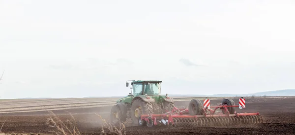 KIEV, UCRANIA - 27 DE MARZO DE 2019: Agricultura, tractores preparando tierras con cultivador de semillero como parte de las actividades de presiembra a principios de la temporada de primavera de las obras agrícolas en tierras de cultivo —  Fotos de Stock