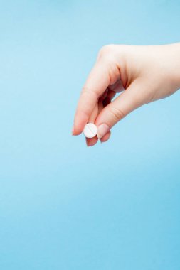 Bir ilaç üzerinde mavi arka plan izole hemşirenin elinde yakın çekim shot