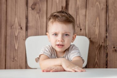 Güzel bir oğlan masada oturuyor. Yakın çekim