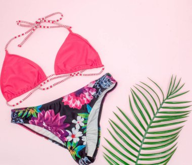 Şapka, mayo ve pembe arka plan üzerinde güneş gözlüğü. Üst görünüm, düz 