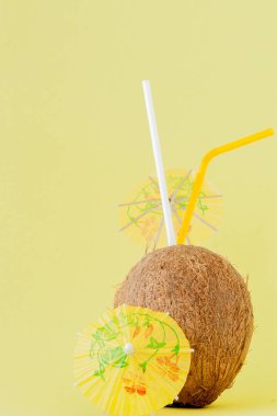 Sarı arka planda bir pipet ile taze Hindistan cevizi kokteyli, kopya alanı