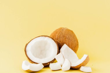 sarı bir arka plan üzerinde izole taze Hindistan cevizi parçaları yakın, tropikal meyve kavramı, düz yatıyordu, pop art, kopya alanı