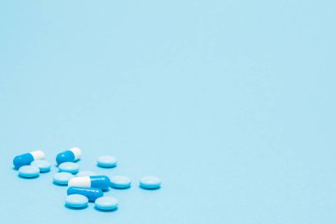 Mavi masaya dağılmış mavi haplar. Özel teklifler için sahte