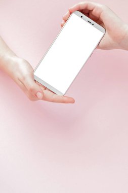 Pembe arka planda bir kadının elinde modern cep telefonu