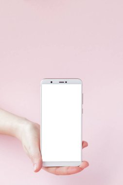 Pembe arka planda bir kadının elinde modern cep telefonu