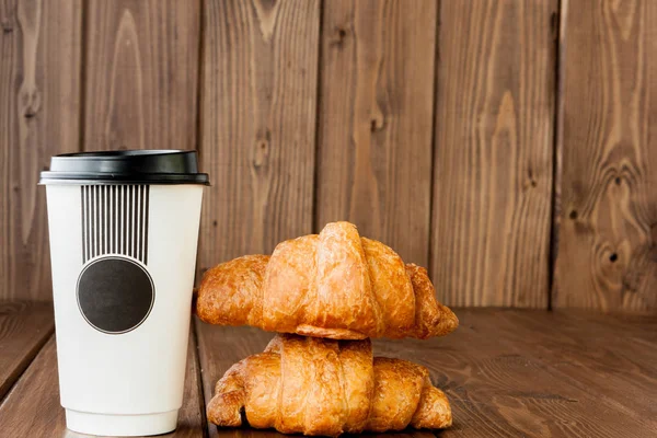 Paper coffee cup and croissants on wooden background, Copy space — Stock Photo, Image