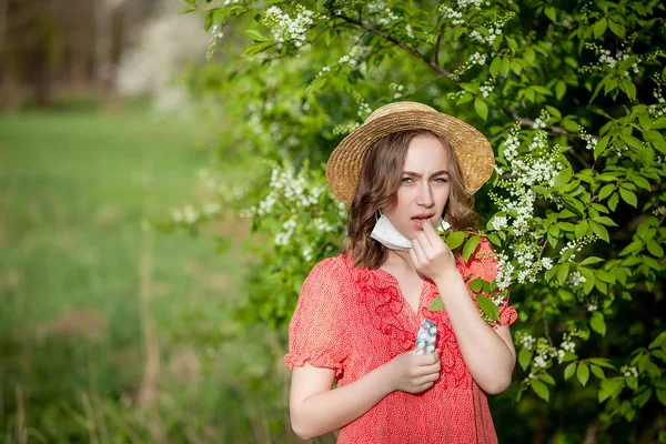 Молодая девушка, сморкающаяся и чихающая в ткани перед расцветом — стоковое фото