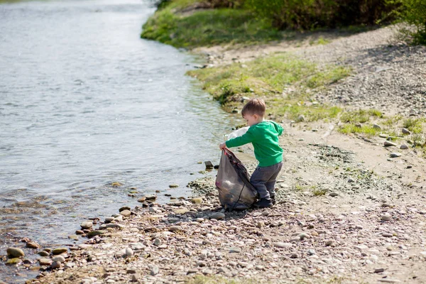 Salva concetto di ambiente, un bambino che raccoglie spazzatura e pl — Foto Stock