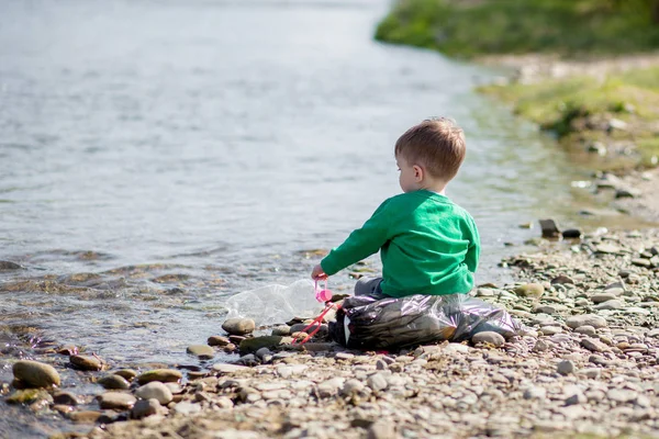 Salva concetto di ambiente, un bambino che raccoglie spazzatura e pl — Foto Stock