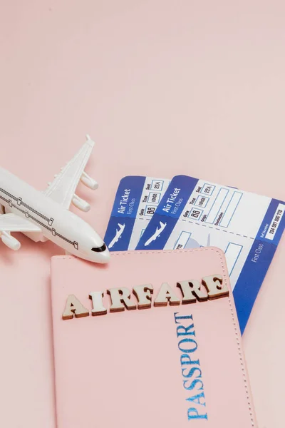 Inscrição "airfare", Airplane, air ticket and money on a pink background. Conceito de viagem, espaço de cópia — Fotografia de Stock