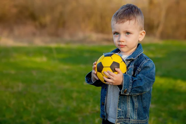 Dwa lata chłopiec utrzymanie piłki nożnej w parku — Zdjęcie stockowe