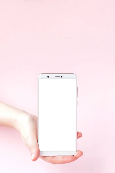 Moderní mobilní telefon v ženské ruce na růžovém pozadí — Stock fotografie