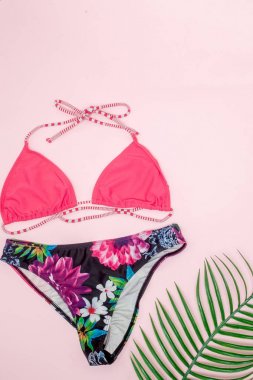 Şapka, mayo ve pembe arka plan üzerinde güneş gözlüğü. Üst görünüm, düz 