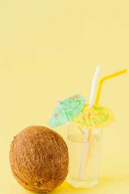 Sarı arka planda bir pipet ile taze Hindistan cevizi kokteyli, kopya alanı