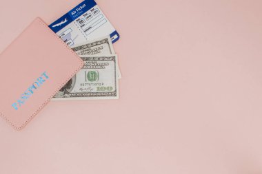 Pasaport, dolar ve uçak bileti, pembe bir arka planda. Seyahat Co