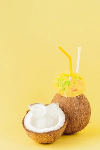 Cóctel de coco fresco con pajitas sobre fondo amarillo, espacio para copiar — Foto de Stock